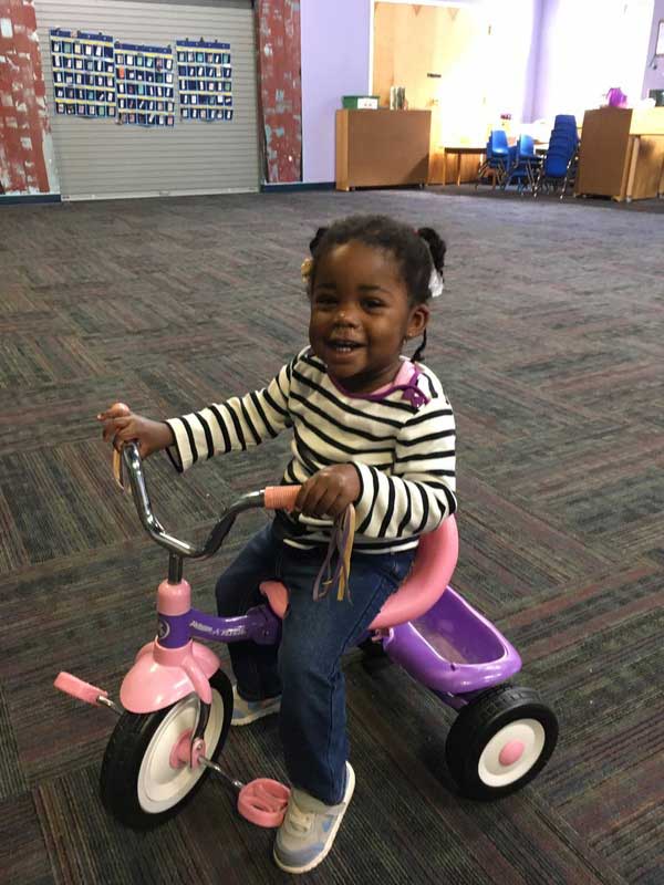 day care child riding tricycle