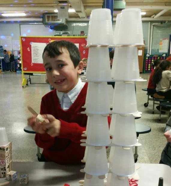 boy in front of stacked cups