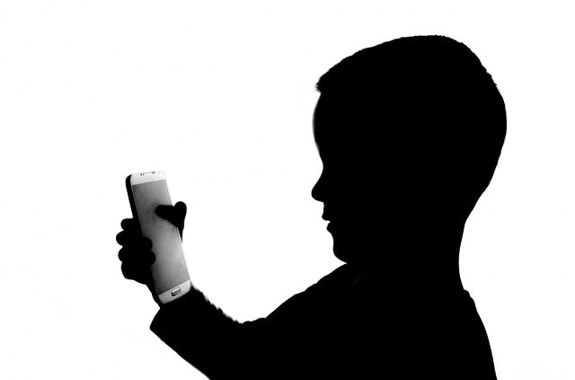silhouette of child using phone