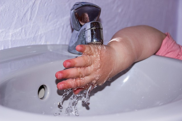 little hand directly under faucet